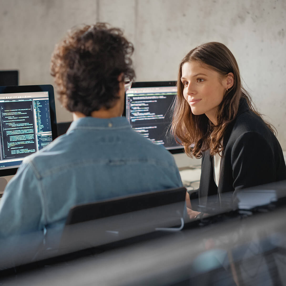 Young developers discussing in front of computers